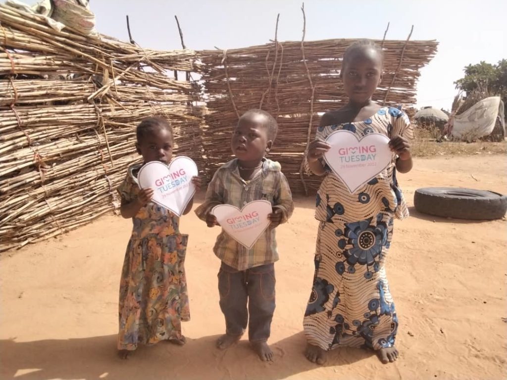 Trois enfants tiennent dans leurs mains un coeur en papier