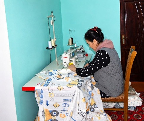 Nargiza devant sa machine à coudre